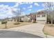 Inviting two-story home featuring a stone facade, attached two-car garage, and a long driveway at 3680 Falling Leaf Ln, Cumming, GA 30041