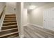 Hallway with stairs features wood-look floors, neutral walls, white trim, and overhead lighting at 3680 Falling Leaf Ln, Cumming, GA 30041