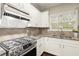 Close-up of kitchen with granite counters, stainless steel appliances, tile backsplash, and hardwood floors at 3680 Falling Leaf Ln, Cumming, GA 30041