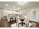 Kitchen eat-in area with natural light and hardwood floors connects to the kitchen with counter seating at 3680 Falling Leaf Ln, Cumming, GA 30041