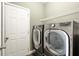 Modern laundry room featuring stainless steel washer and dryer, and extra storage space at 3680 Falling Leaf Ln, Cumming, GA 30041