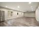 Bright living area showcases wood-look flooring, recessed lights, stainless refrigerator and an exterior door with windows at 3680 Falling Leaf Ln, Cumming, GA 30041