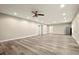 Open-concept living room boasting modern gray floors, recessed lighting, and a stainless steel refrigerator at 3680 Falling Leaf Ln, Cumming, GA 30041