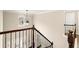 View of the home's staircase with dark wood railing and an ornate pendant light fixture in the foyer at 3680 Falling Leaf Ln, Cumming, GA 30041