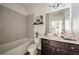 Bathroom with large grey tiles, a soaking tub, and modern dark wood vanity at 754 Aerial Way, Atlanta, GA 30312