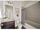 Clean bathroom with a tub and shower combo, dark vanity, and floral decor at 754 Aerial Way, Atlanta, GA 30312