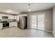 Well-lit kitchen with stainless steel appliances, a large refrigerator, and sliding glass door at 810 N Carter Dr, Jonesboro, GA 30236