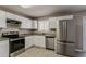 Bright kitchen with stainless steel appliances, granite countertops, and white cabinets at 810 N Carter Dr, Jonesboro, GA 30236