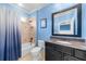 Charming bathroom features tile walls, a vanity with granite counters, and a tub with a shower and blue shower curtain at 135 Newcastle Ct, Roswell, GA 30076