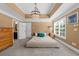 Comfortable bedroom with tray ceiling, large windows, and en-suite bathroom access at 135 Newcastle Ct, Roswell, GA 30076