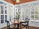Breakfast nook surrounded by large windows with white shutters, with seating for four and stylish light fixture at 135 Newcastle Ct, Roswell, GA 30076