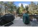 Wooden deck overlooking lush backyard with a gas grill and space for entertaining at 135 Newcastle Ct, Roswell, GA 30076