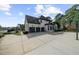 Exterior view of home featuring a three car garage and basketball court at 135 Newcastle Ct, Roswell, GA 30076