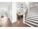 Bright foyer features hardwood floors, a staircase, and an open view to the living room with elegant decor and lighting at 135 Newcastle Ct, Roswell, GA 30076