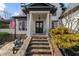 Inviting front porch with stone steps, elegant columns, and cozy seating area at 135 Newcastle Ct, Roswell, GA 30076