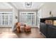 Bright living room features large windows, hardwood floors, and cozy sitting area with ottoman at 135 Newcastle Ct, Roswell, GA 30076