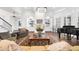 Spacious living room with a fireplace, built-in shelving, comfortable seating, and a piano near the windows at 135 Newcastle Ct, Roswell, GA 30076