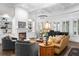 Sunlit living room features a fireplace, custom built-ins, comfortable seating, and a grand piano near bay windows at 135 Newcastle Ct, Roswell, GA 30076