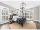Main bedroom features hardwood floors, 4-poster bed, plantation shutters, and a jute rug at 135 Newcastle Ct, Roswell, GA 30076