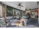 Inviting screened porch, with ceiling fans, comfortable seating, and wooded backyard views at 135 Newcastle Ct, Roswell, GA 30076