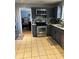 Well-equipped kitchen with gray cabinets, stainless steel appliances, and tile floors for a functional cooking space at 232 Rockingham Dr, Loganville, GA 30052