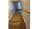 Carpeted staircase with a wooden handrail leading to the upper level of the house at 232 Rockingham Dr, Loganville, GA 30052