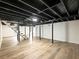 Spacious basement featuring modern light wood floors, white walls, black ceiling, and stairs at 2308 Mark Trl, Decatur, GA 30032