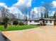 Inviting home with a green lawn, set back from the street with a long, concrete driveway at 2308 Mark Trl, Decatur, GA 30032