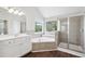 Bright bathroom featuring a soaking tub, glass shower, and double vanity at 4416 Water Mill Dr, Buford, GA 30519