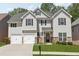 Charming two-story home featuring a manicured lawn, stone accents, and a two-car garage at 4416 Water Mill Dr, Buford, GA 30519