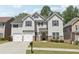 Inviting two-story house with a lush green lawn, a double garage, and dark window shutters at 4416 Water Mill Dr, Buford, GA 30519