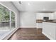 Bright dining area next to kitchen with white cabinets, granite counters, and a large window at 4416 Water Mill Dr, Buford, GA 30519