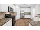 Well-equipped kitchen features stainless steel appliances, granite countertops, and white cabinets at 4416 Water Mill Dr, Buford, GA 30519
