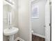 Charming powder room features a pedestal sink, an oval mirror, and wood-look flooring at 4416 Water Mill Dr, Buford, GA 30519
