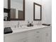 Modern bathroom featuring double sinks, quartz countertop, and dark wood framed mirrors at 511 Burton Dr # 805, Alpharetta, GA 30009
