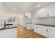 Bright open kitchen with white cabinetry, black counters, hardwood floors, and stainless steel faucet at 578 Center Hill Nw Ave, Atlanta, GA 30318