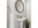 Powder room featuring pedestal sink, round mirror, and modern fixtures at 103 Bryon Ln, Acworth, GA 30102