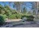 Lush backyard with mature trees, patio area, and privacy bushes at 2000 Variations Dr, Atlanta, GA 30329
