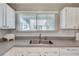 Bright kitchen with stainless sink, stone countertop, and window providing natural light at 2000 Variations Dr, Atlanta, GA 30329