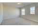 Sunlit bedroom features plush carpeting, light walls, and two windows offering natural light at 117 Belvedere Rd, Mcdonough, GA 30253