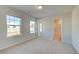 Bright bedroom features carpeted floors, neutral walls, and bathroom access through a doorway at 117 Belvedere Rd, Mcdonough, GA 30253
