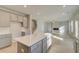 Open-concept layout features a kitchen island with living room view, fireplace, large windows, and staircase at 117 Belvedere Rd, Mcdonough, GA 30253