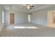 Spacious main bedroom featuring plush carpet, ceiling fan, and tray ceiling at 117 Belvedere Rd, Mcdonough, GA 30253