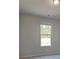 Neutral bedroom featuring a large window with natural light, grey walls, and carpeted floors at 112 Felicity Pike, Locust Grove, GA 30248
