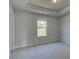 This bedroom features neutral walls, carpet flooring, a window, and a tray ceiling at 112 Felicity Pike, Locust Grove, GA 30248