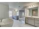 Bright primary bathroom with double vanities, soaking tub, and open doorway to bedroom at 120 Felicity Pike, Locust Grove, GA 30248