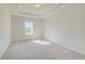 Bright bedroom featuring neutral carpeting, tray ceiling, and a window providing plenty of natural light at 120 Felicity Pike, Locust Grove, GA 30248