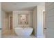 Contemporary bathroom featuring a freestanding tub, tiled shower, and an open doorway into the main bedroom at 120 Felicity Pike, Locust Grove, GA 30248