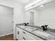 Bathroom with dual sinks, granite countertops, wood-look floors, and black hardware at 326 Oakview Way, Canton, GA 30114