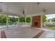 Spacious covered patio with a brick fireplace, ceiling fans, and a view of the community pool and slide at 326 Oakview Way, Canton, GA 30114